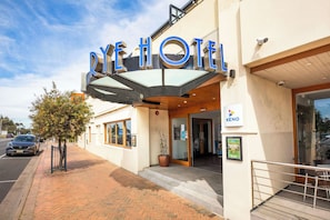A hotel entrance with a modern design, a visible sign for the hotel, and a KENO sign indicating a gaming area.