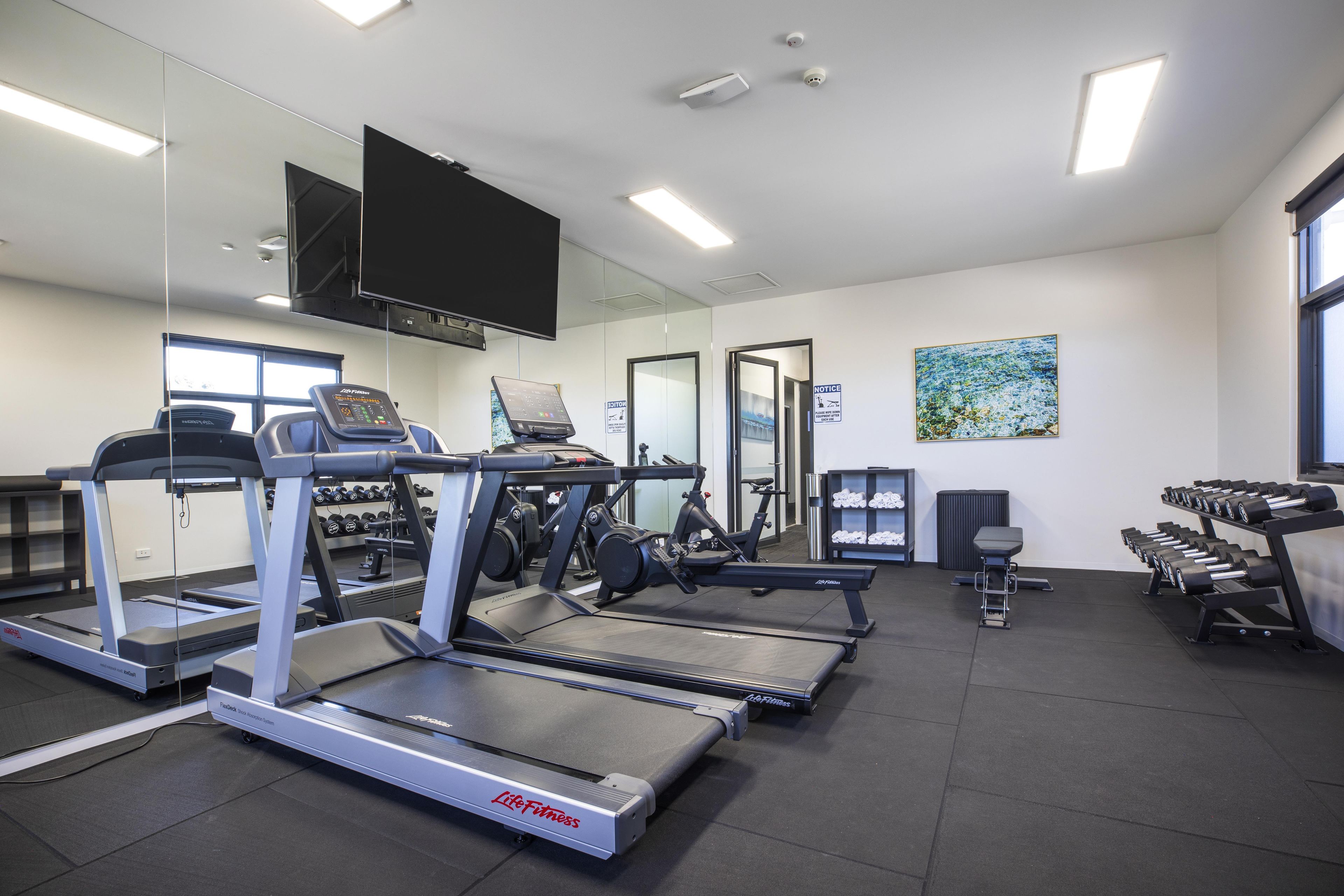 Ein Fitnessstudio mit Laufbändern, Ergometer und Kurzhanteln.