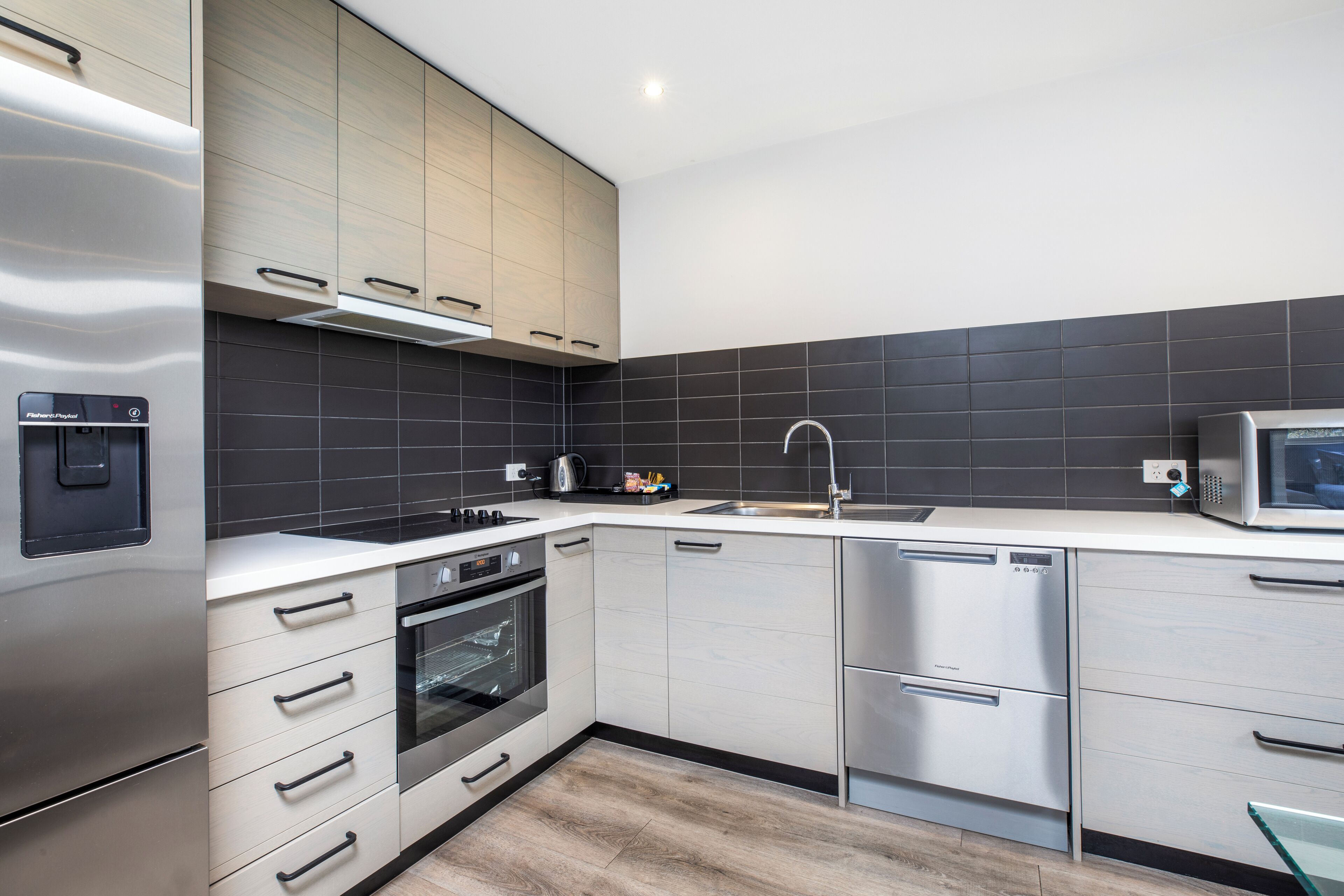 A modern kitchen with stainless steel appliances, a built-in oven, and a dishwasher.