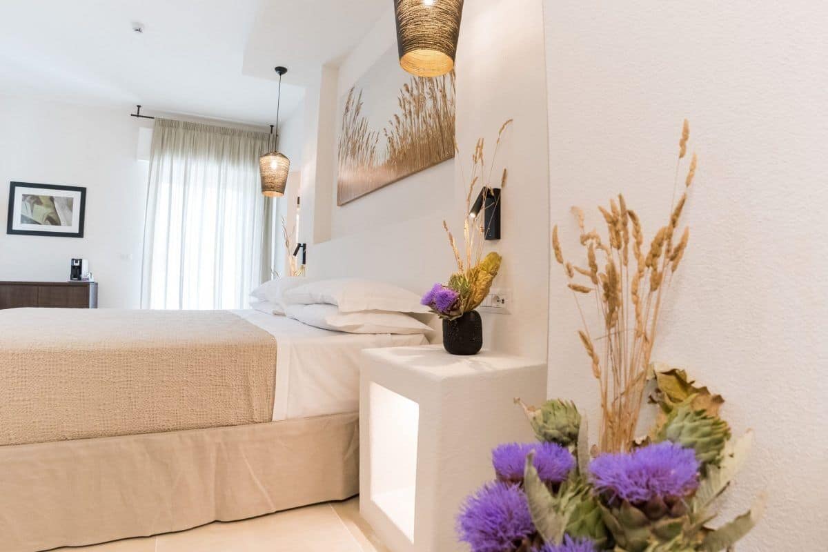 Un dormitorio con cama, mesita de noche y una obra de arte colgada en la pared.