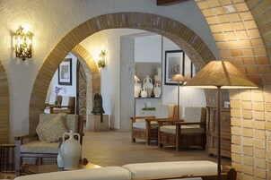 A cozy interior with a brick archway, wooden furniture, and decorative items.