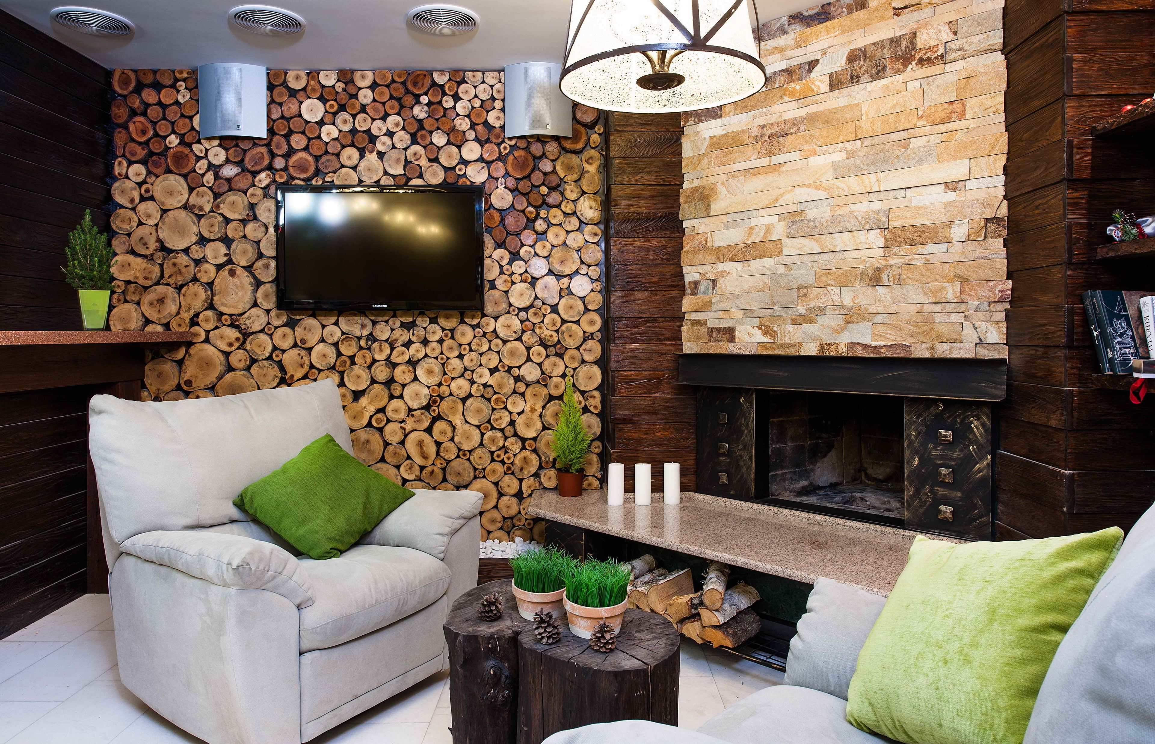 A modern living room with a stone wall, a fireplace, a flat-screen TV, and a comfortable seating area.
