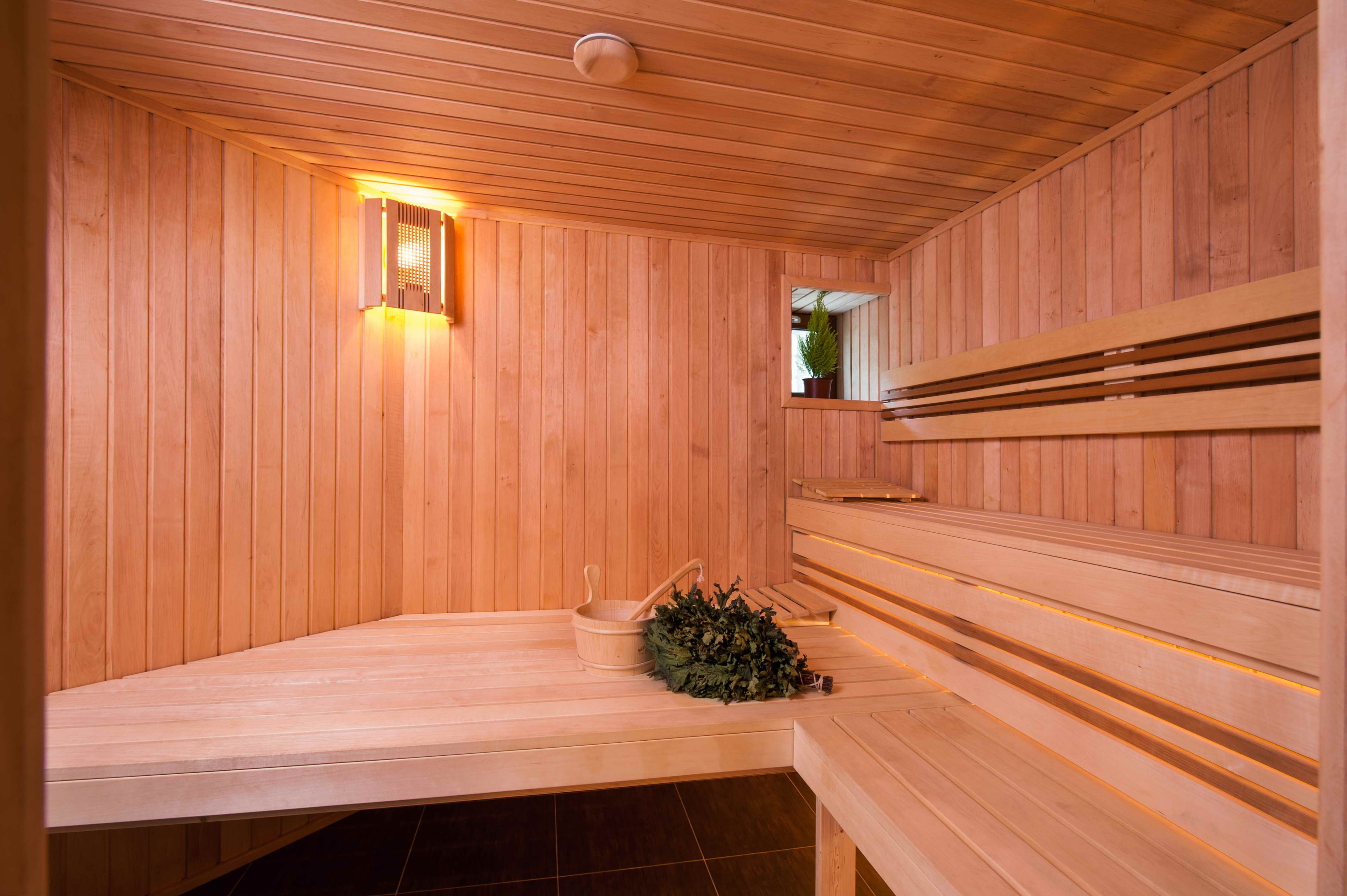 Uma sauna de madeira com bancos e uma pequena janela.
