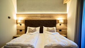 A neatly made bed with a wooden headboard and two bedside lamps.