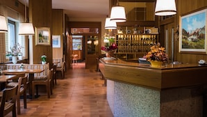 Un restaurante con decoración de madera, una zona de bar y una disposición de mesas.