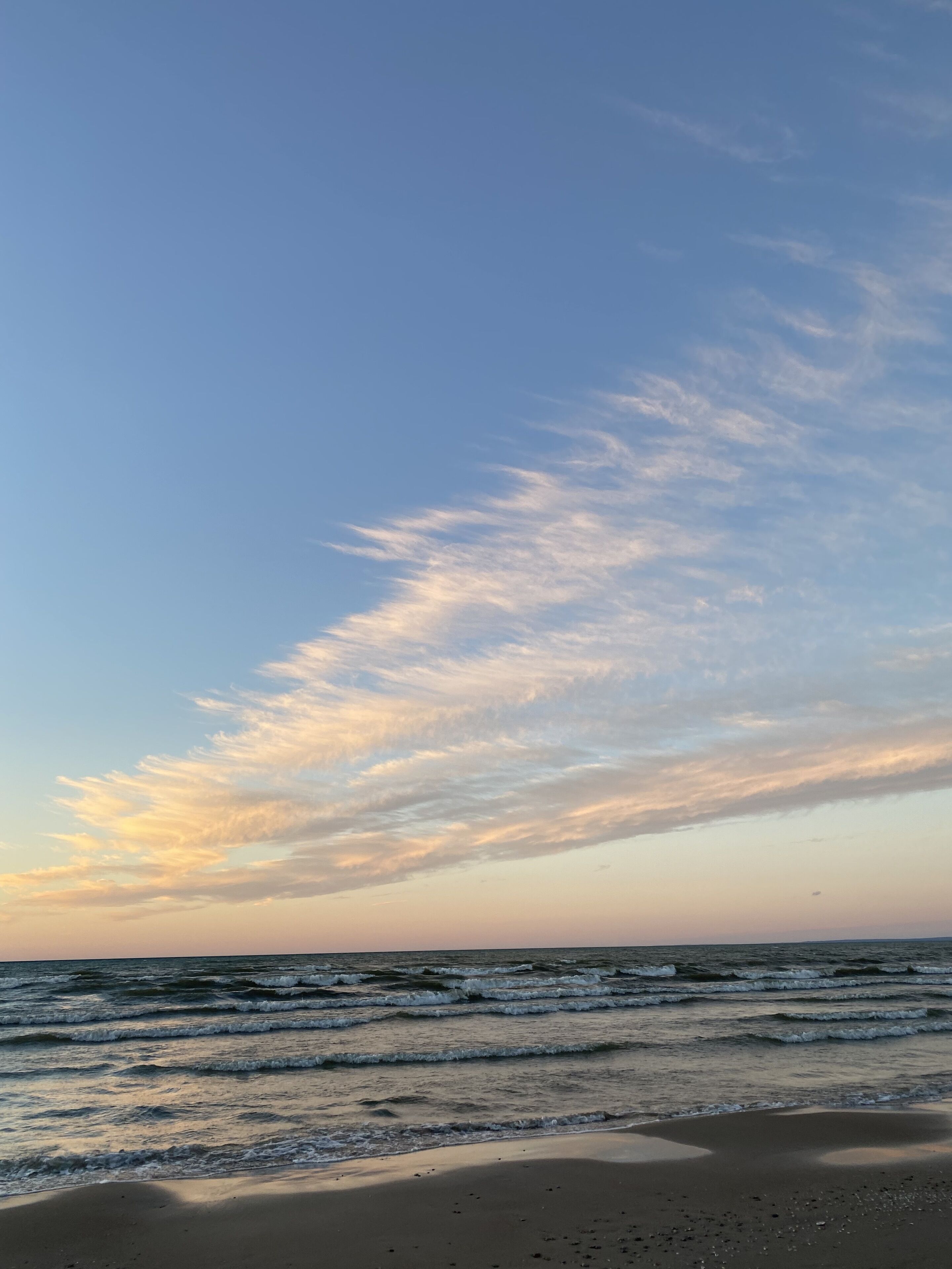 En strand med bølger og en klar himmel.