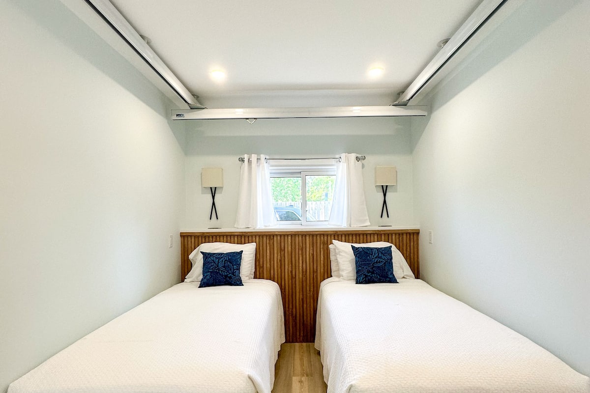 A twin room with two beds, a window, and a ceiling light.