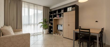 Uma sala de estar moderna com sofá, mesa de jantar e rack para TV.