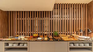 A buffet setup with various food items and a modern wooden wall design.