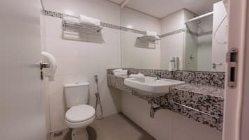 A bathroom with a toilet, sink, and shower.
