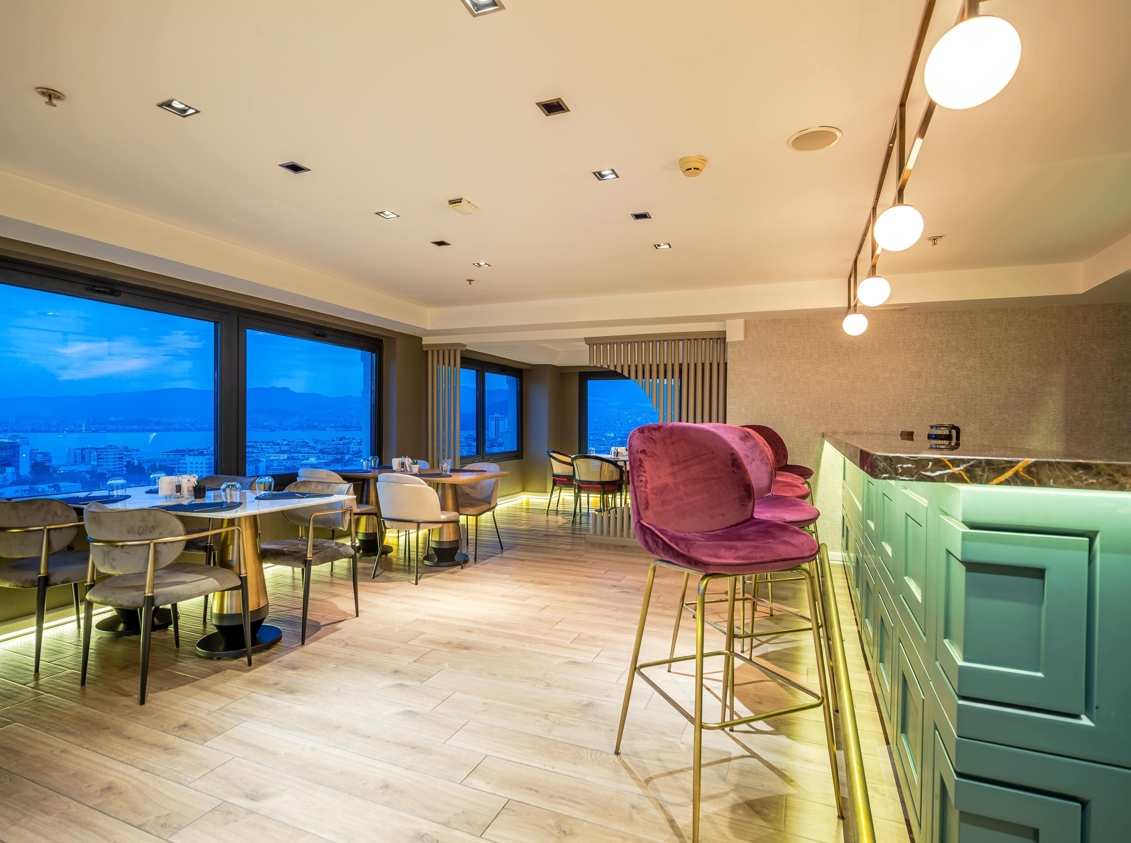 Un comedor moderno con vistas a la ciudad, suelo de madera y muebles contemporáneos.