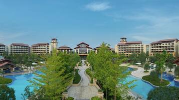 A resort with multiple buildings, a central pool area, and surrounding greenery.