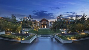 Un hotel grande con un patio central, varias edificaciones y una entrada bien iluminada.