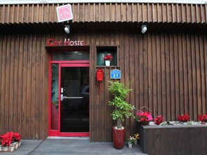 A City Hostel with a red door, a mailbox, and a sign indicating the number 31.