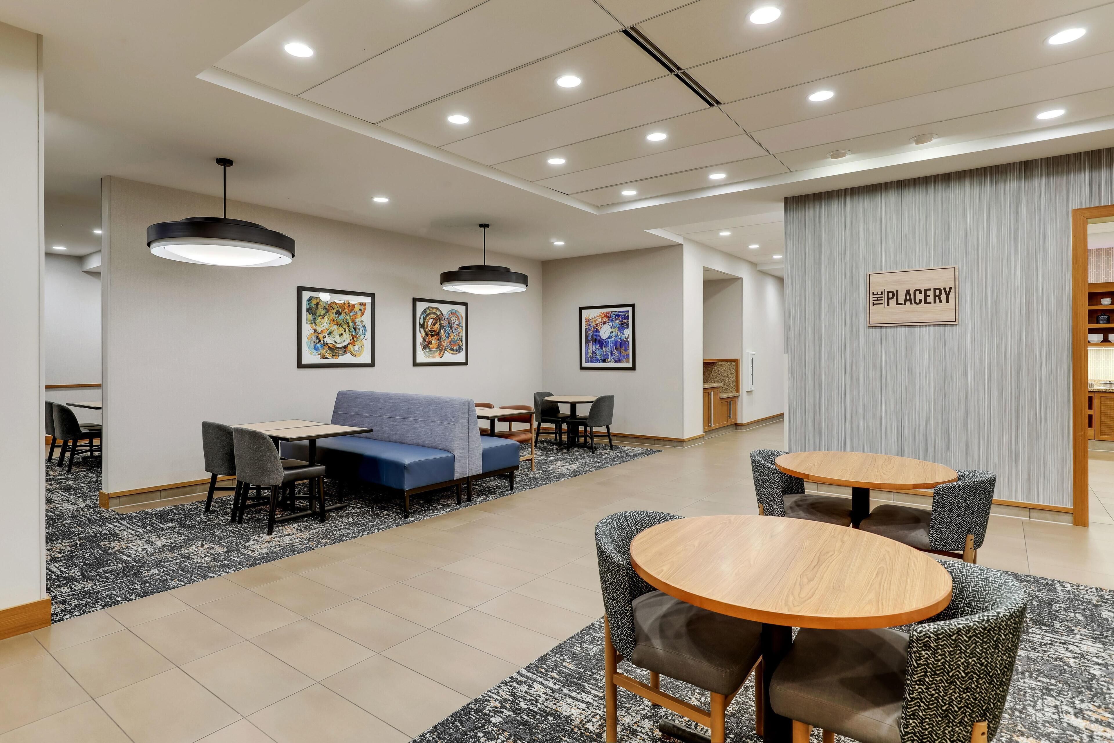 A modern interior with seating areas, artwork on the walls, and a sign indicating a place for dining or resting.
