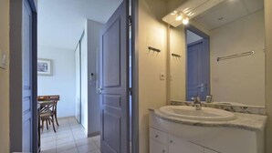 A bathroom with a large sink, mirror, and towel rack.