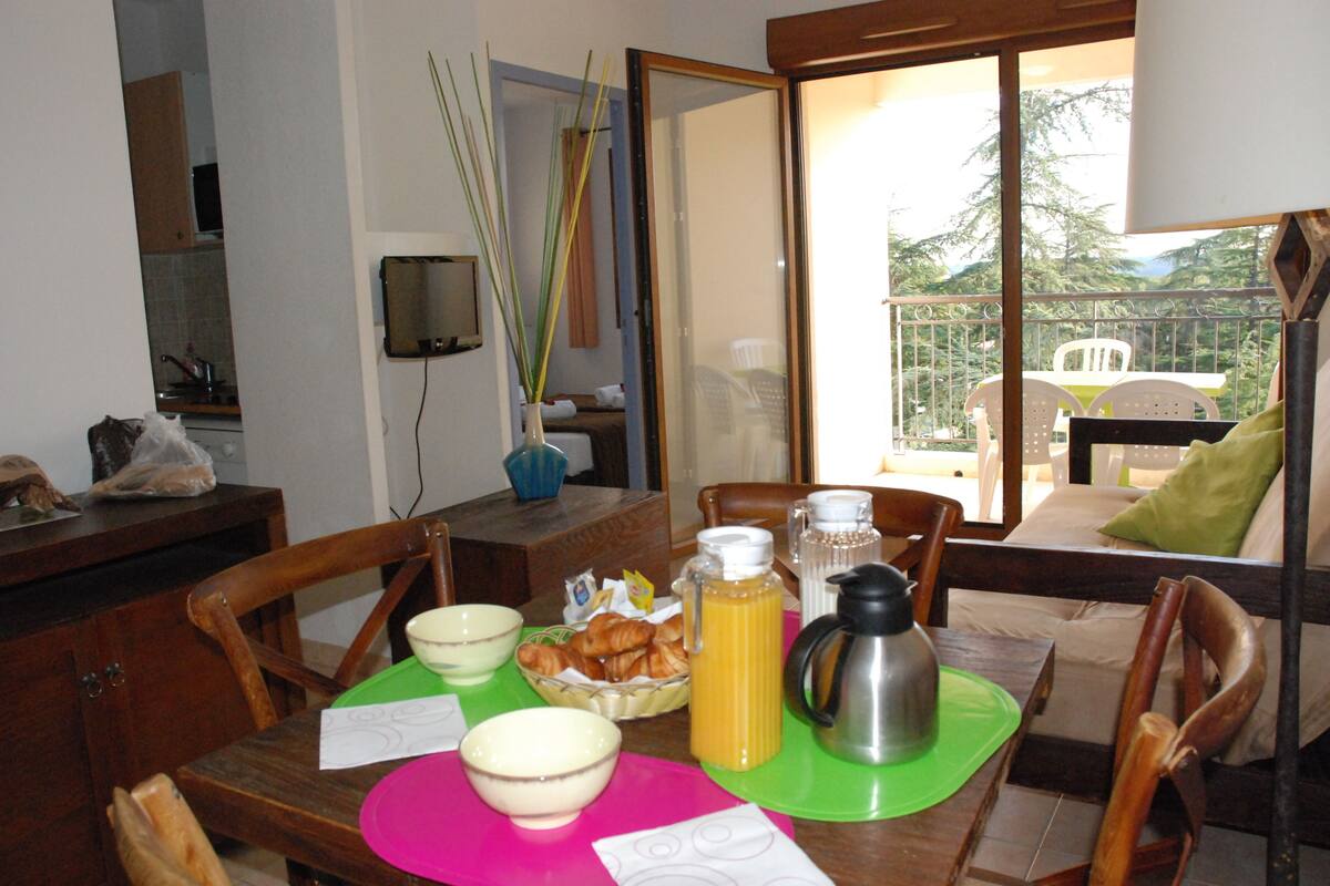 A breakfast table with bowls, a coffee pot, and a bottle of orange juice.