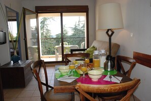 Un coin repas avec une table mise pour le petit-déjeuner, comprenant des bols, des verres et une cafetière.