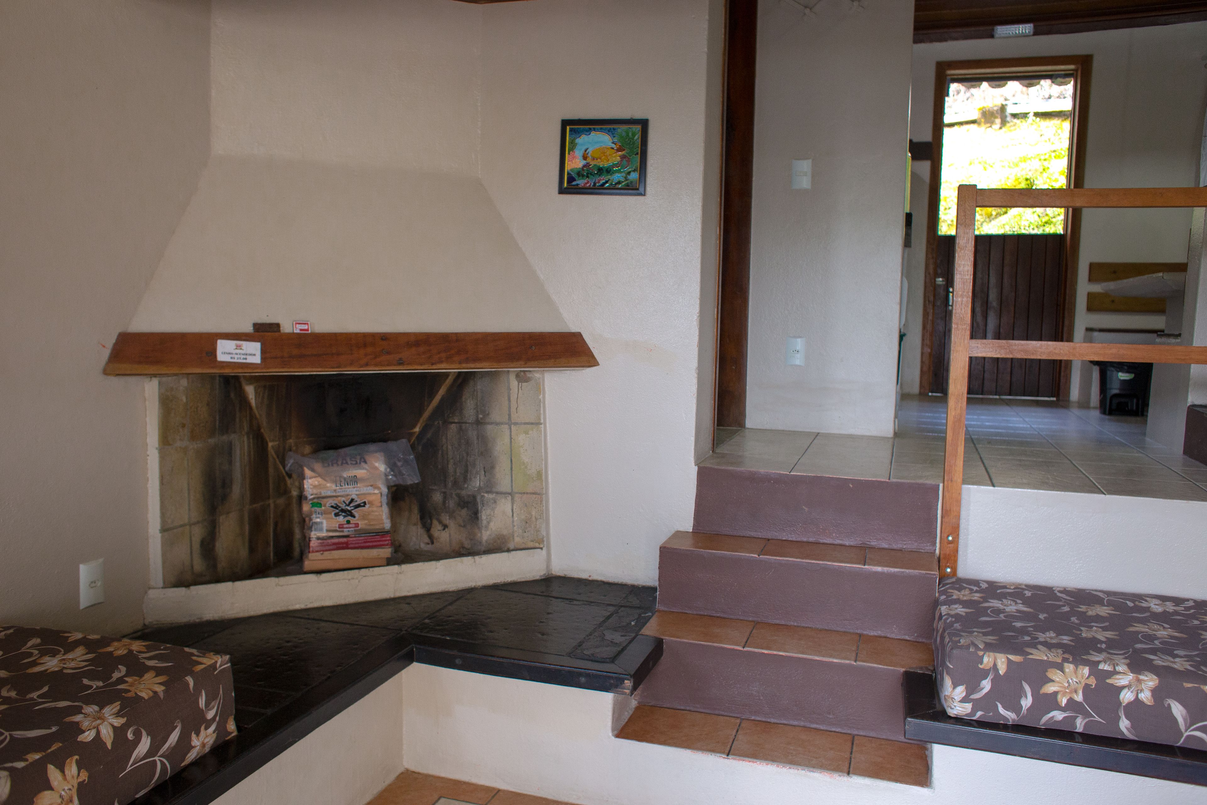 Una escalera con barandilla de madera y un banco al final.
