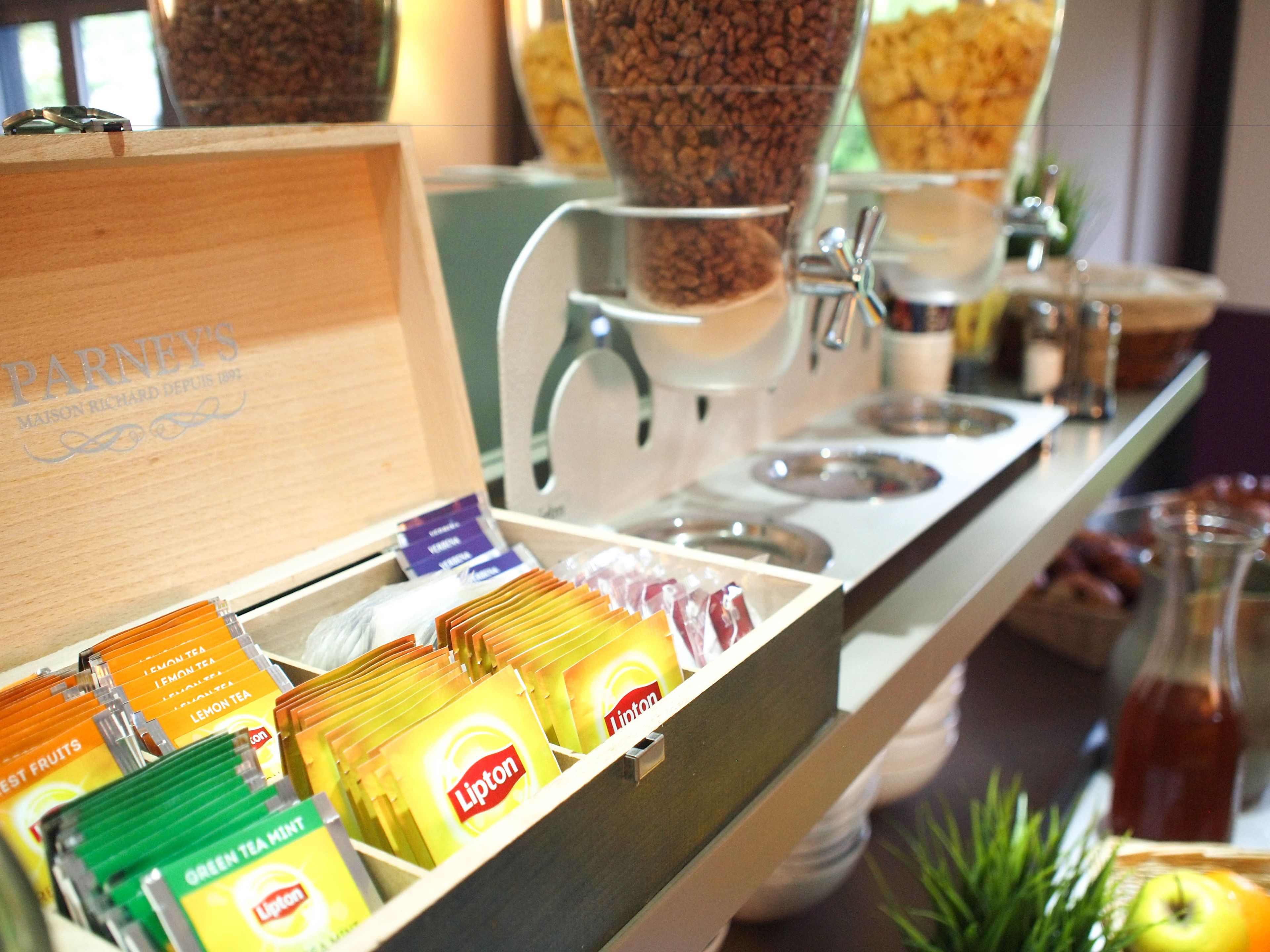 A buffet area with various tea and fruit options, including Lipton and green tea mint.