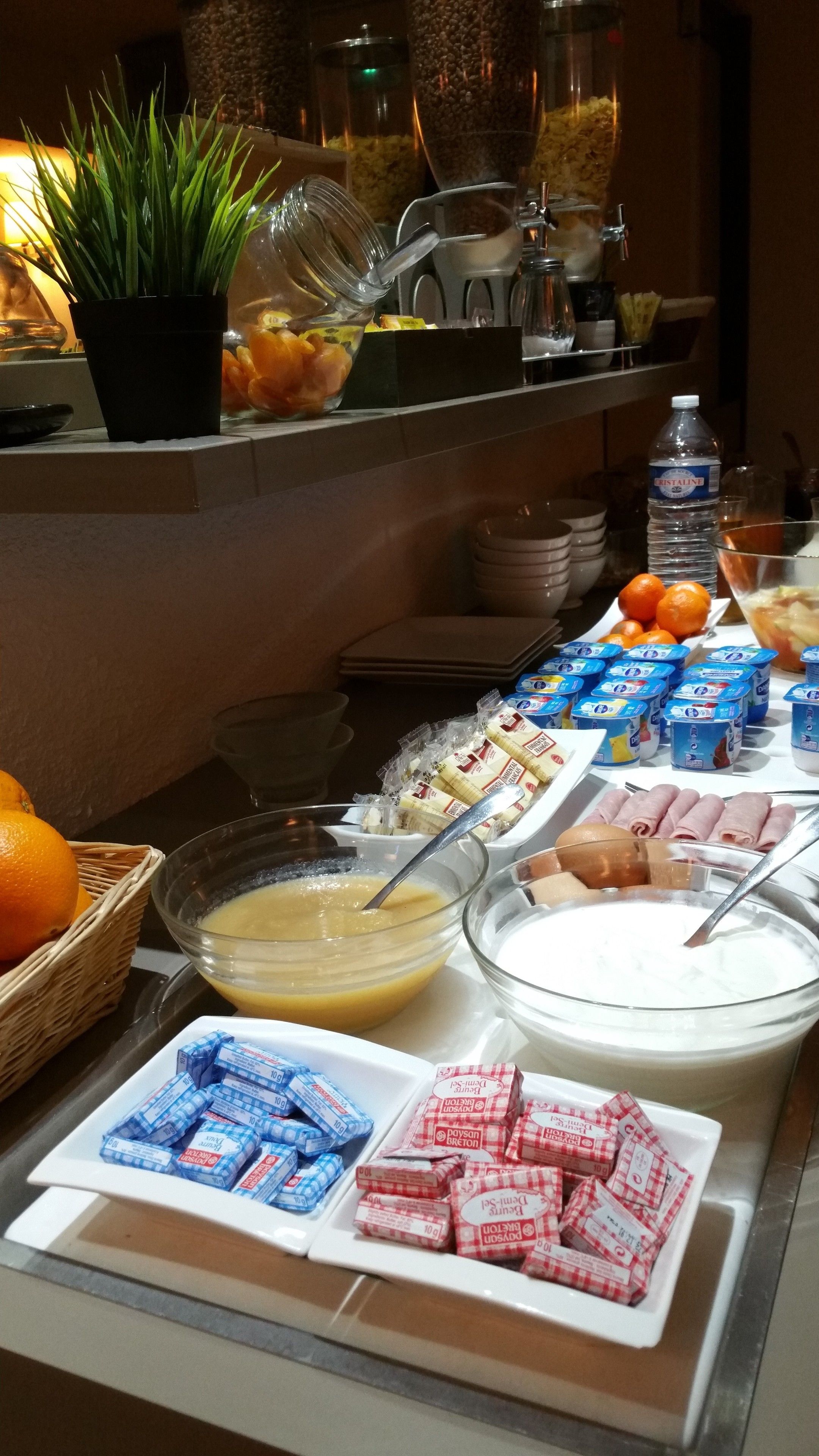 Un bufé con diversos alimentos, como frutas, productos lácteos y aperitivos envasados.