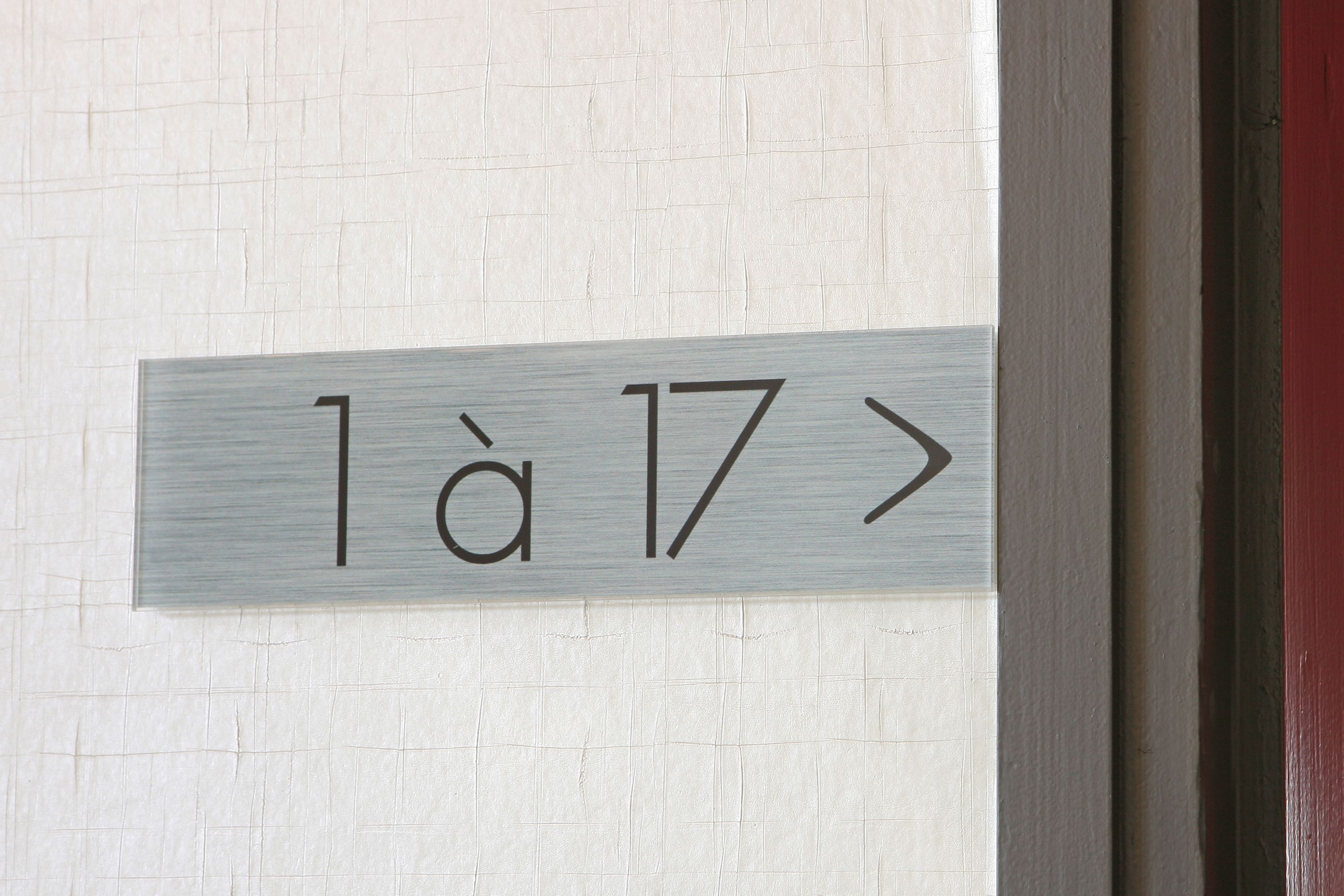 Un panneau indiquant les numéros de chambre avec l’inscription « 1 à 17 ».