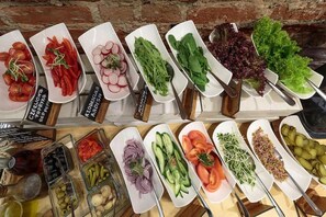 Diverse verse groenten en fruit gepresenteerd op witte borden, met labels in een vreemde taal.
