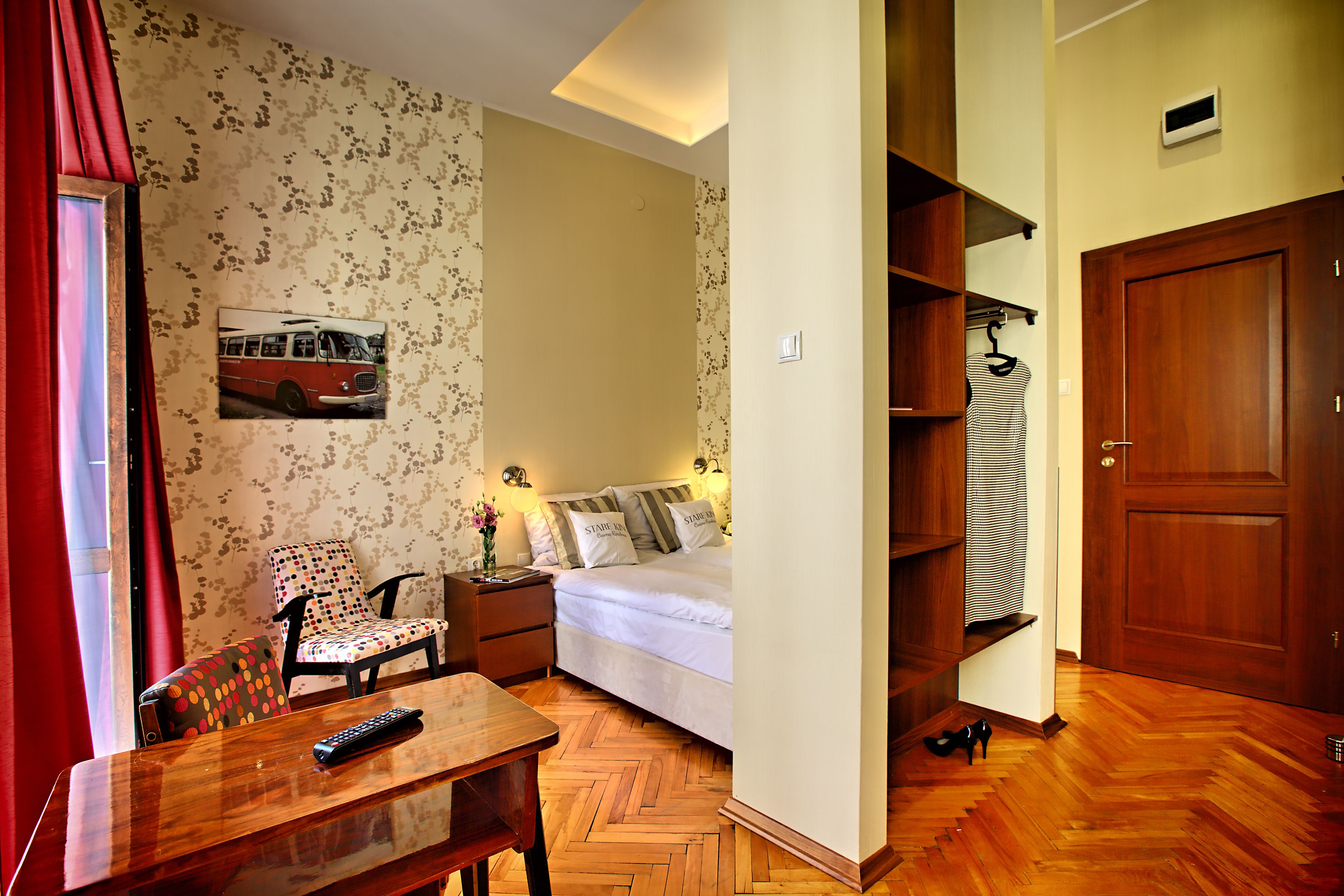Un dormitorio con cama, una silla, una mesa y un armario.