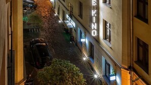Une vue nocturne d’une rue bordée d’immeubles, dont un hôtel dont l’enseigne est illuminée.