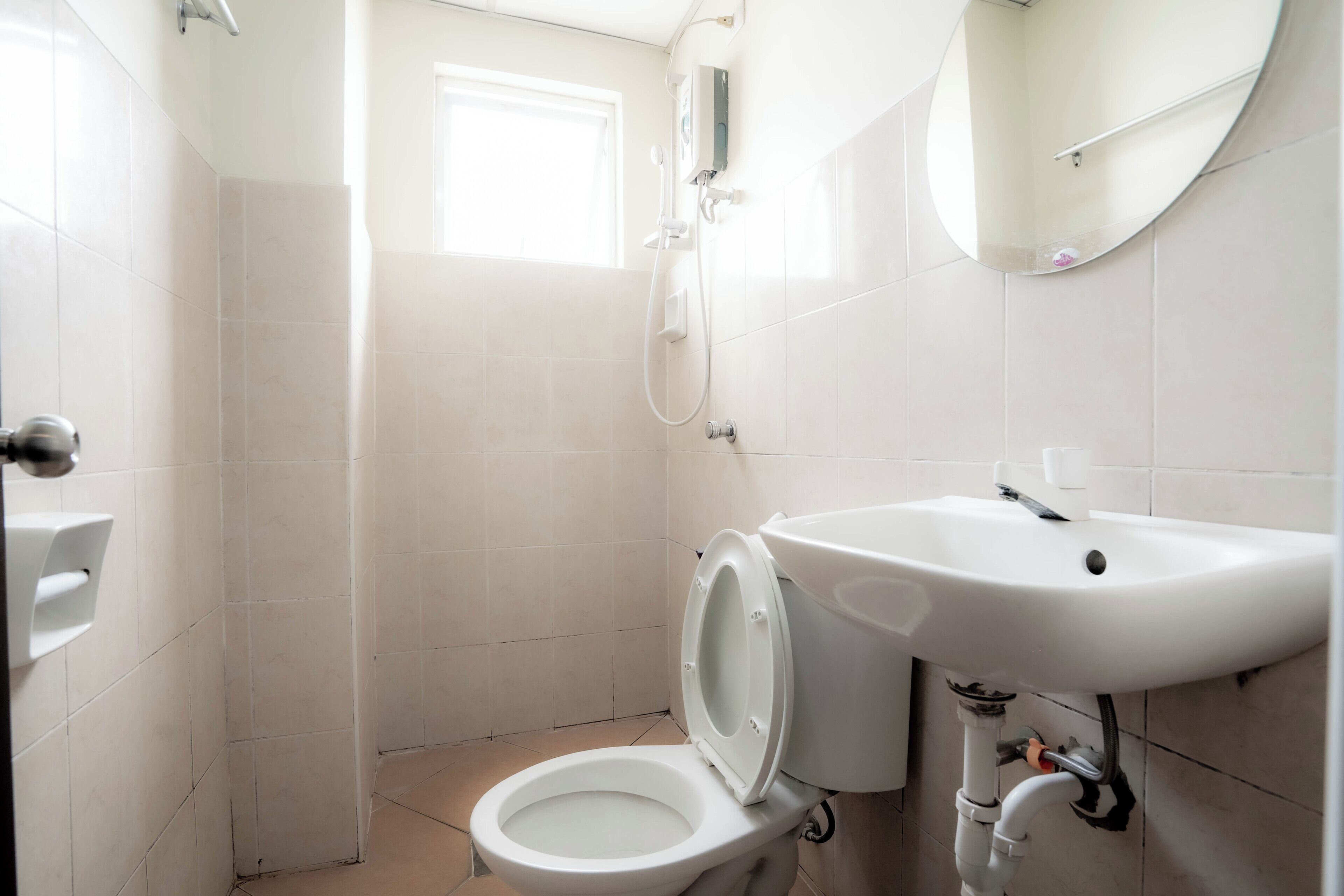 A small, modern bathroom with a toilet, sink, and shower.