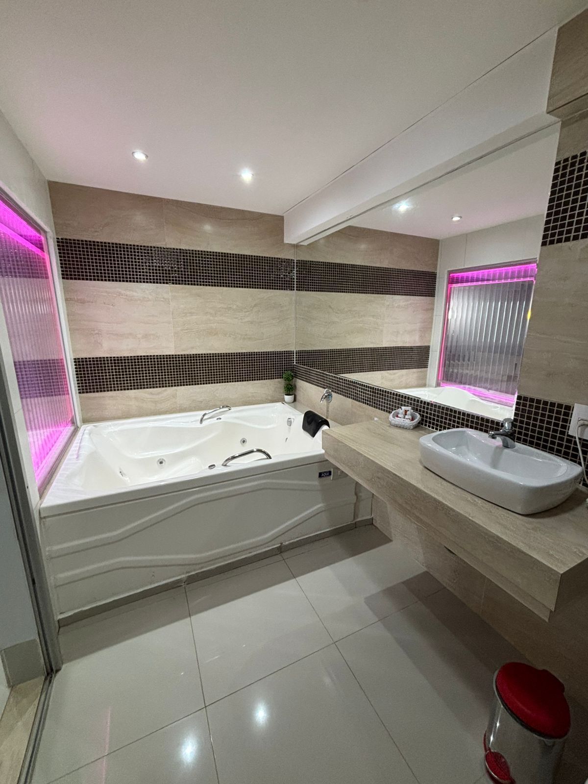 Ein modernes Badezimmer mit einer freistehenden Badewanne, einem Waschtisch und einem Spiegel.