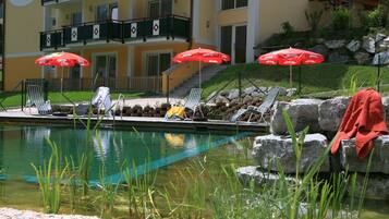 Een seizoensgebonden buitenzwembad, een natuurlijk zwembad