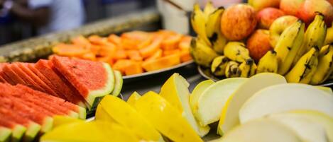 A fruit display with watermelon, mango, bananas, and apples.