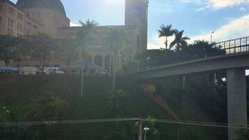 A view of a building with a dome and a tower, a bridge, and palm trees.