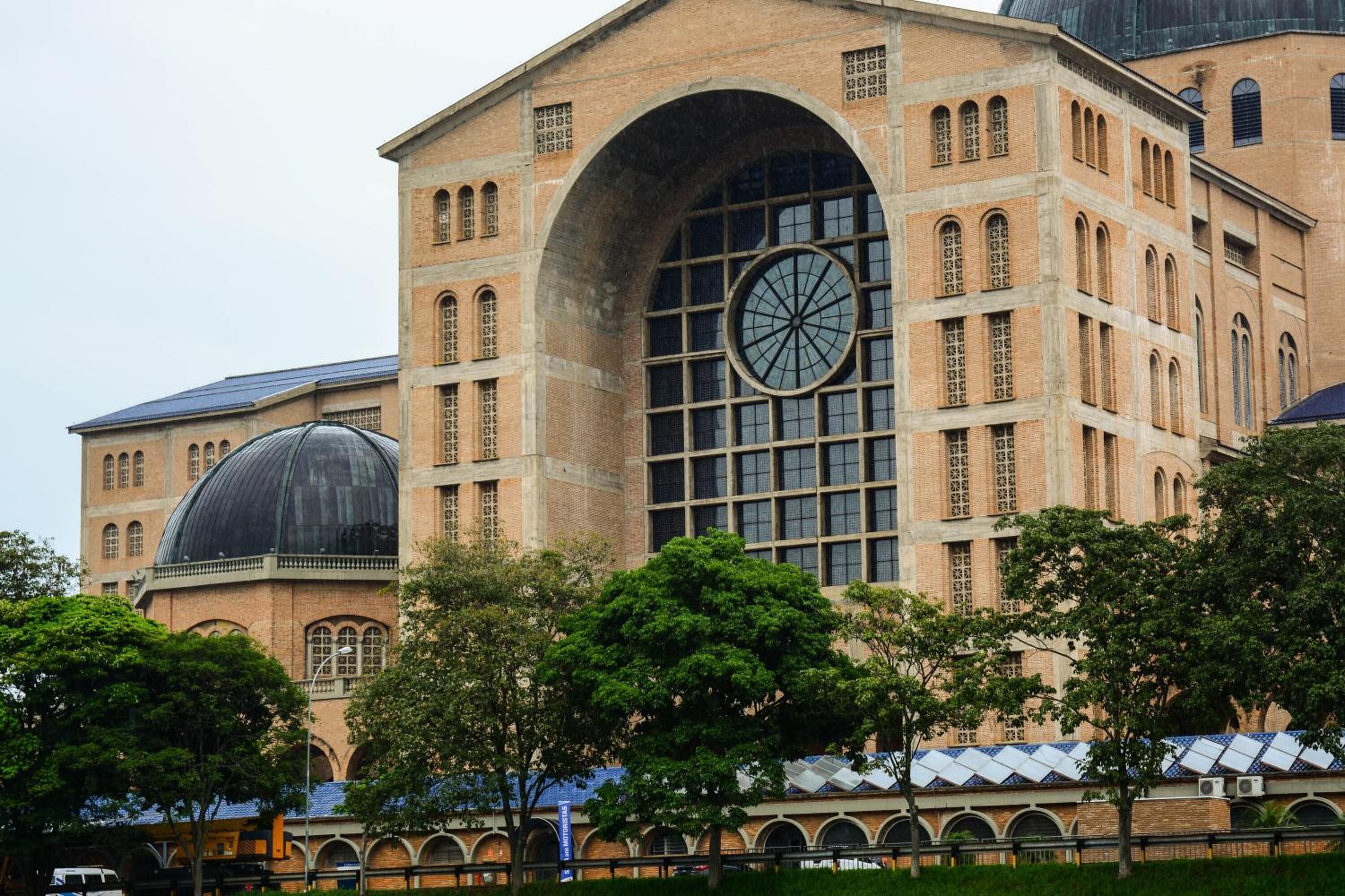 A large, historic building with a prominent arched window and a dome structure.