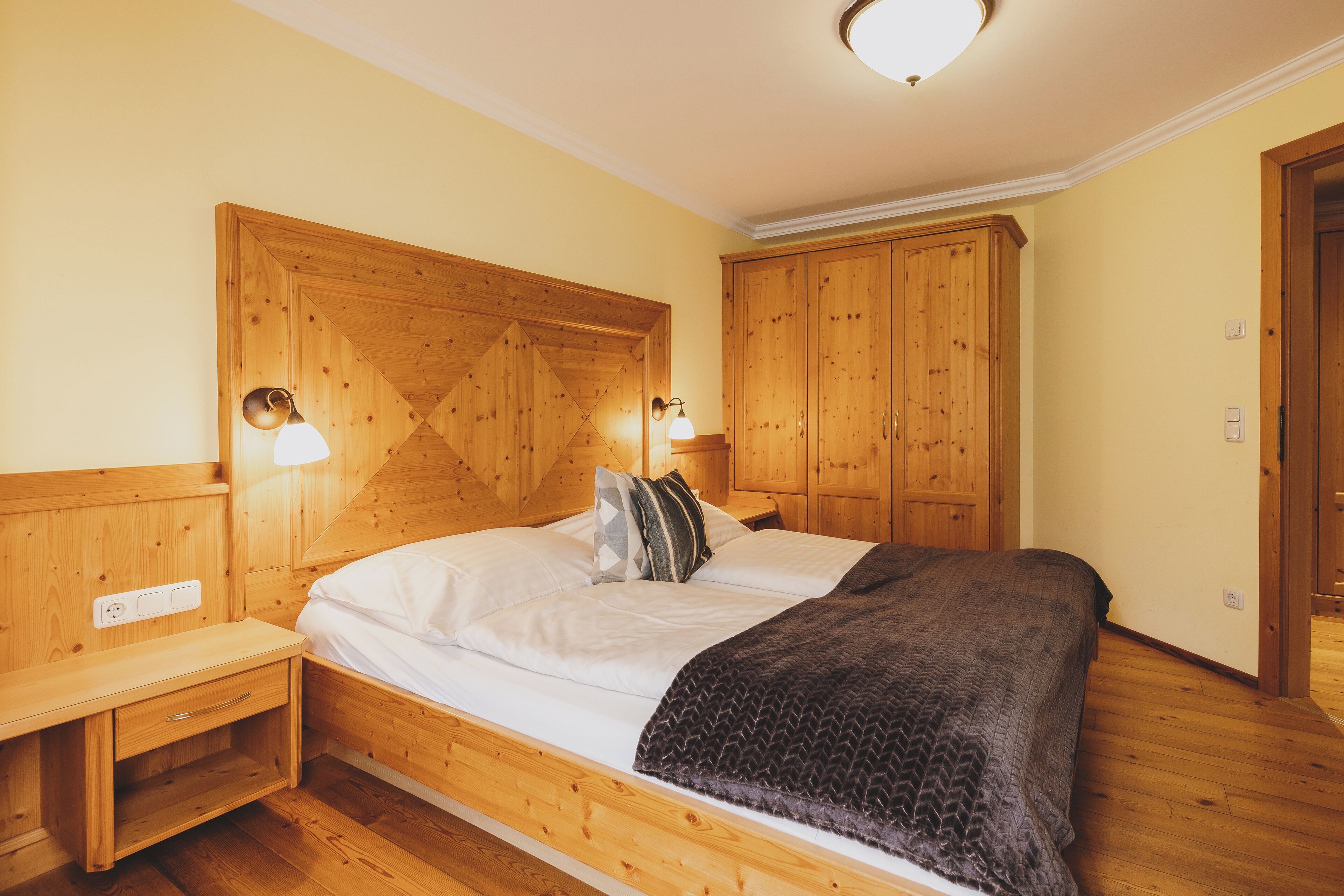 A wooden bed with a headboard, bedside tables, and a nightstand.