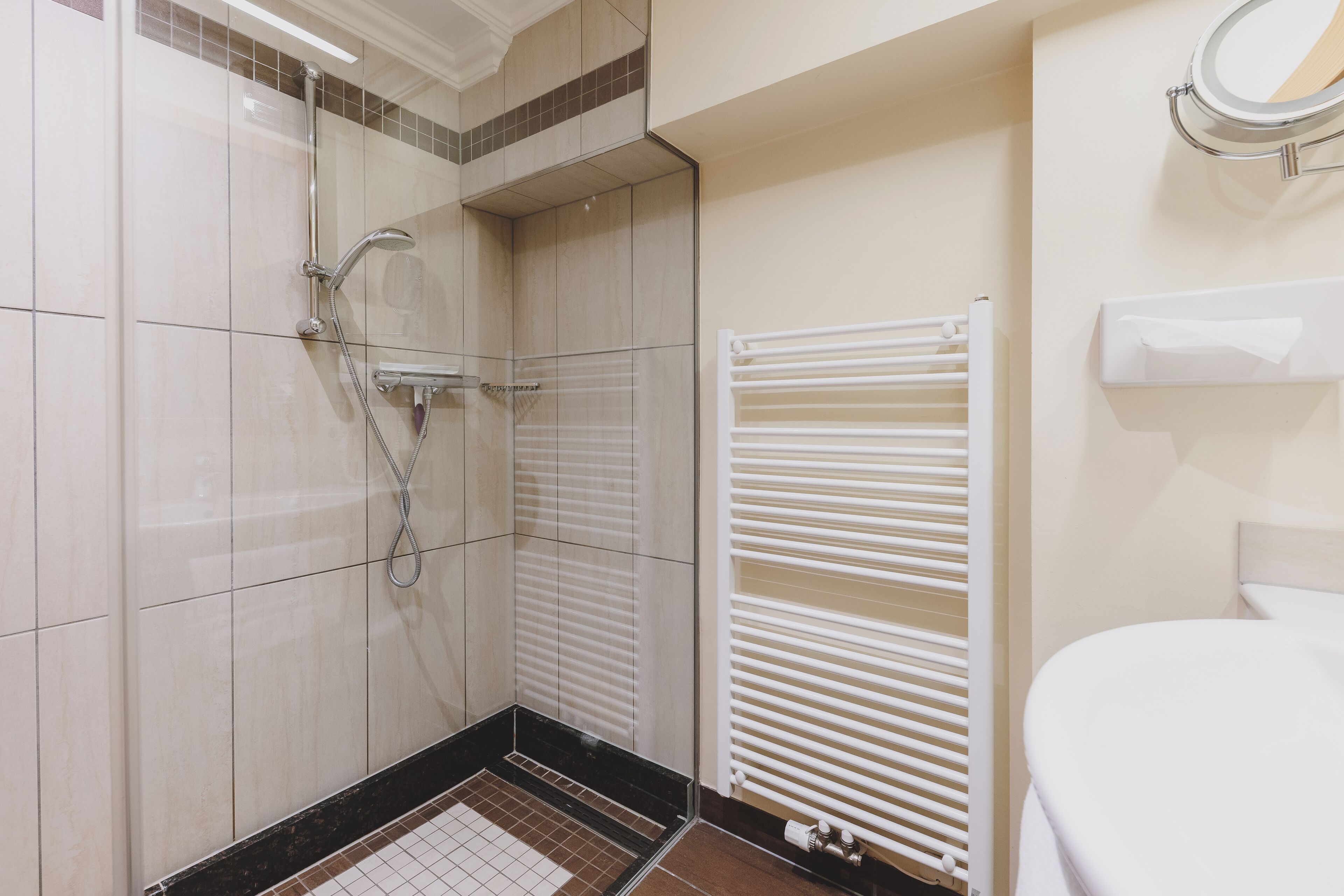 Ein Badezimmer mit Dusche, Toilette und Handtuchhalter.