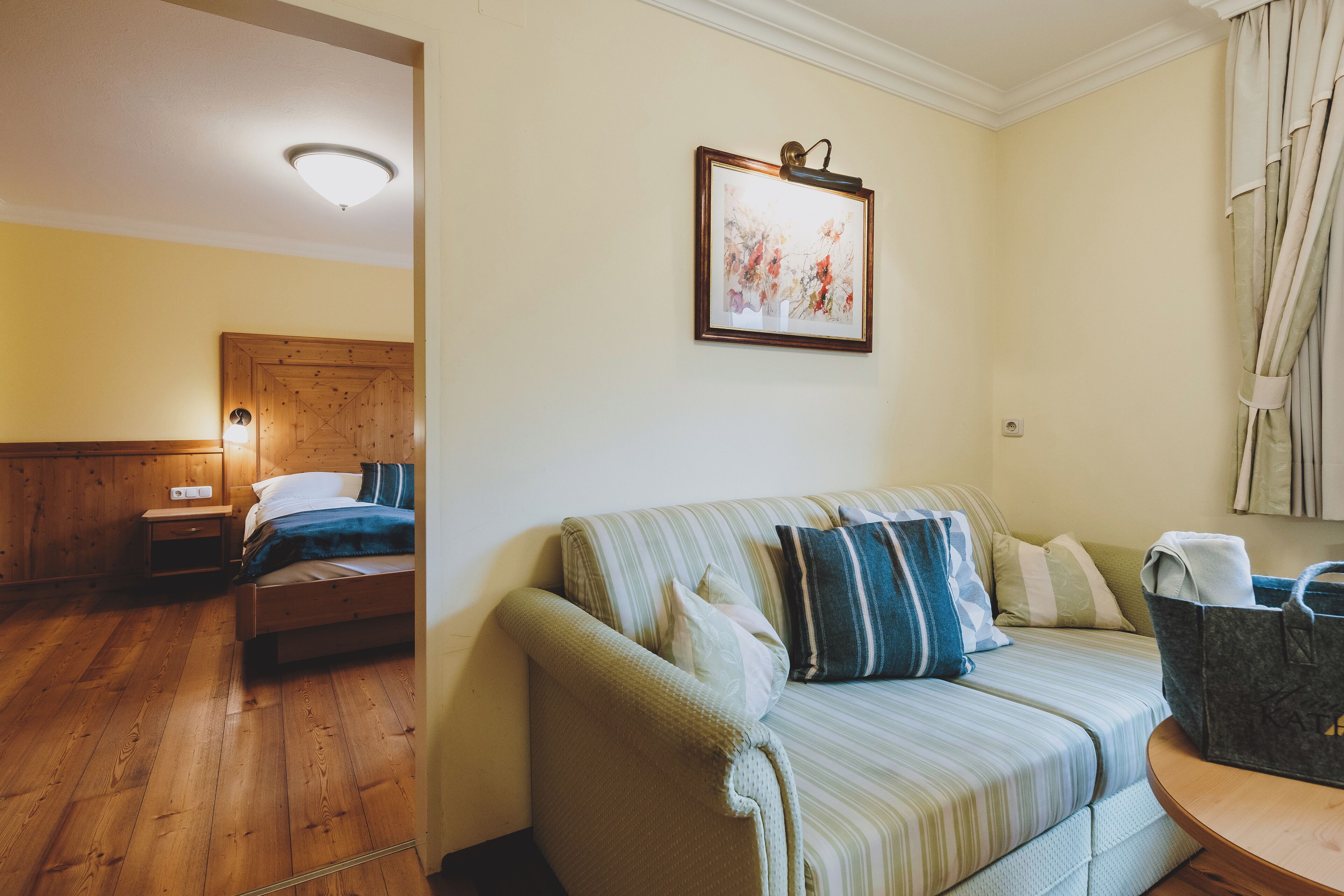Una habitación acogedora con una cama, un sofá y una mesita.