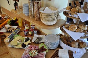 Un bufé de desayuno con diversas opciones de comida, como pan, bollería, frutas y bebidas.