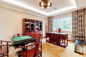 A room with a wooden desk, a green table, and a cabinet. - Zhongmei Hotel (Jinggangshan)