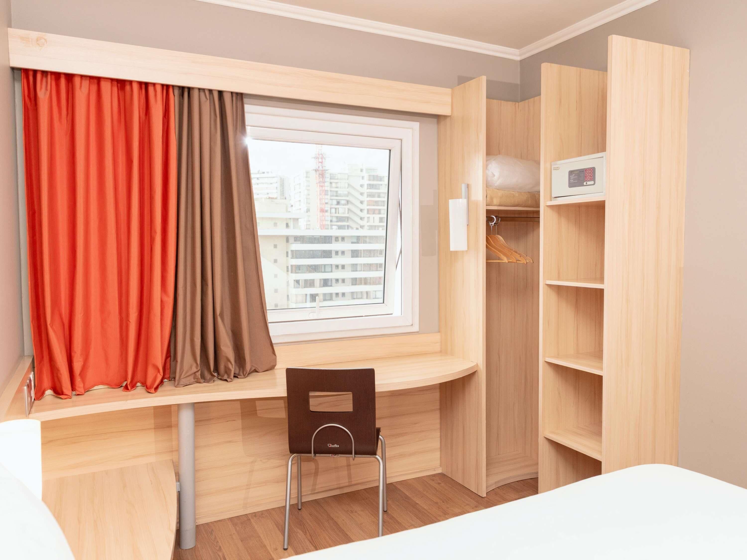 Una habitación con escritorio, silla y armario con estantes.