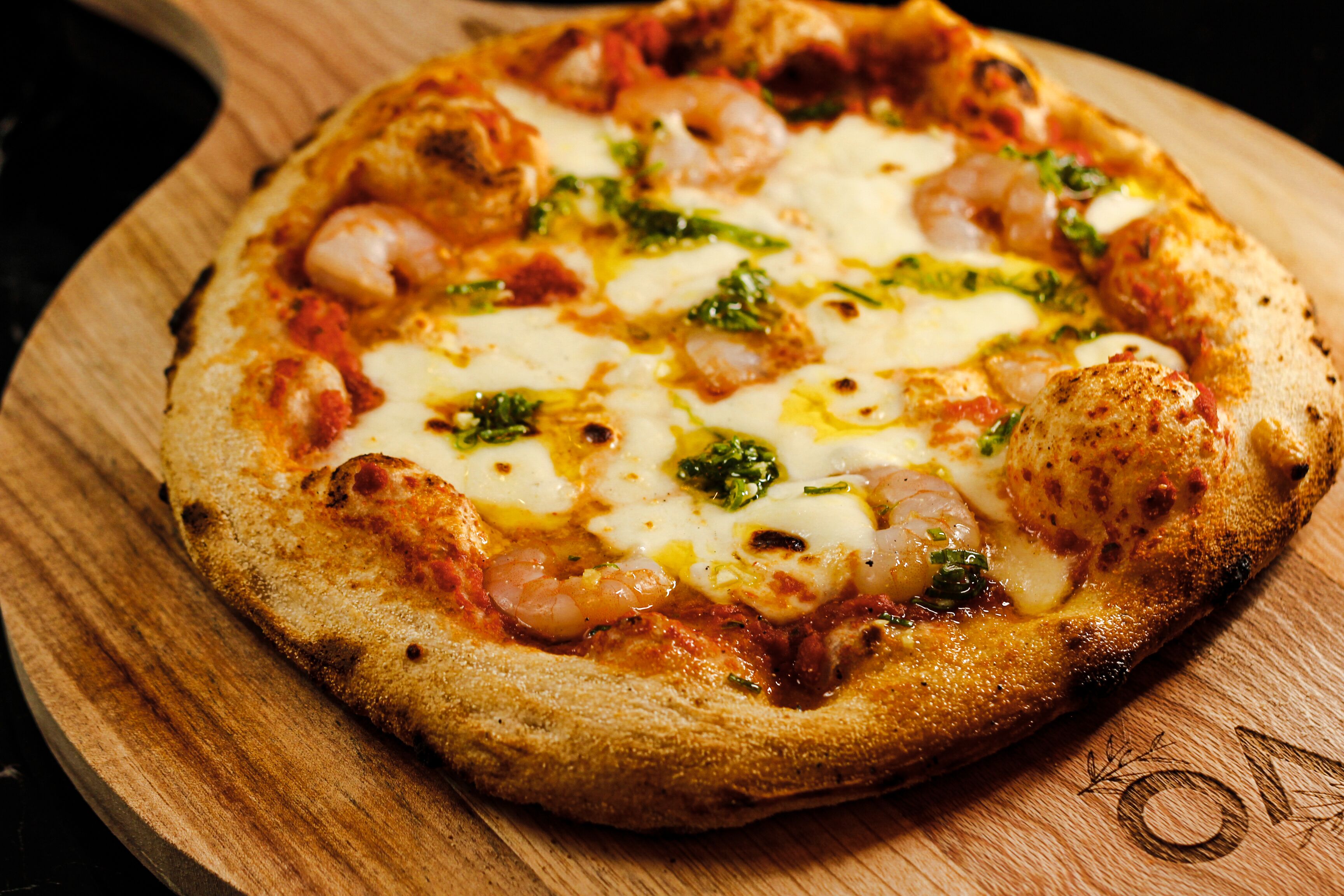 A pizza on a wooden board.