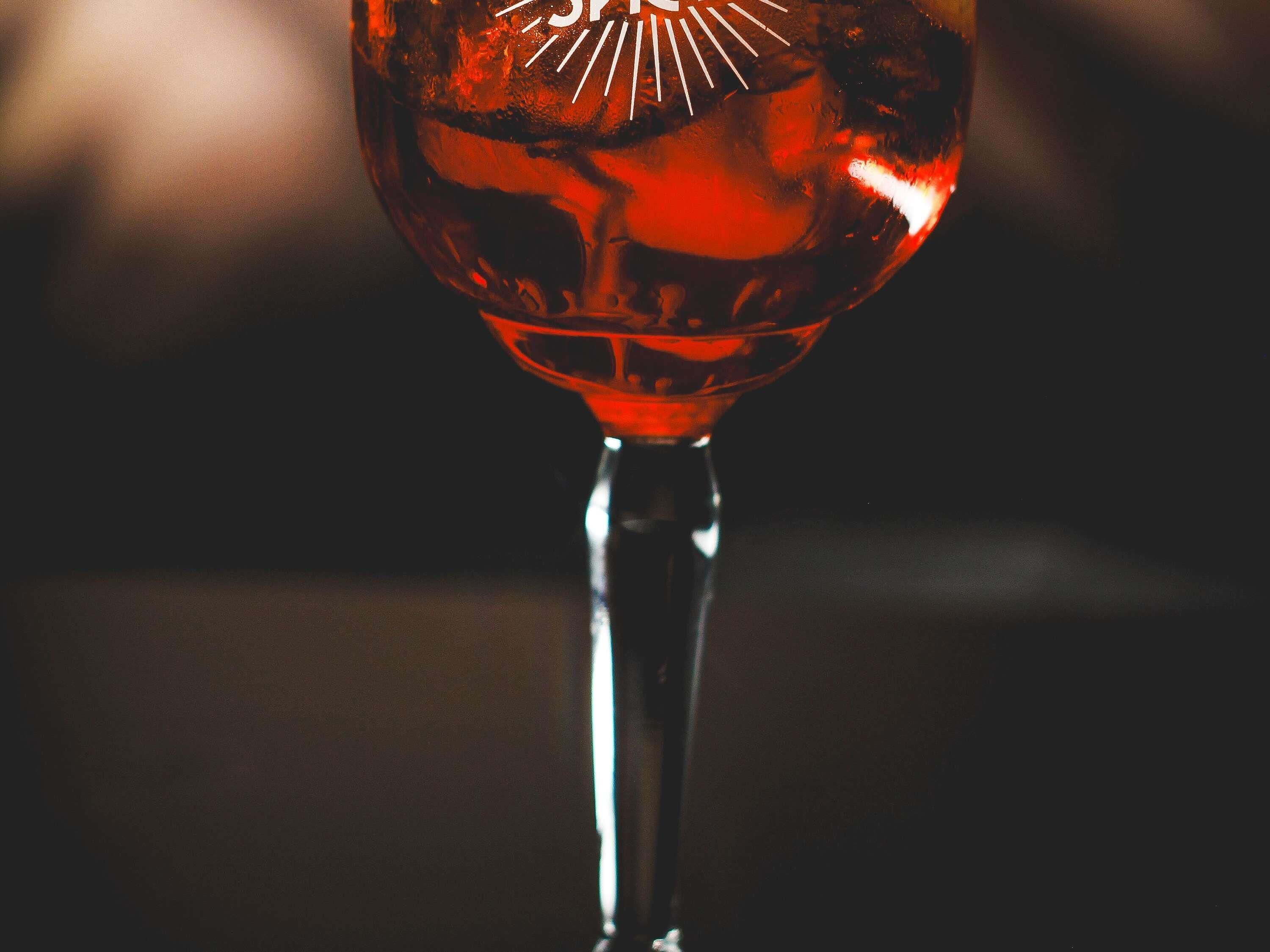 Un gros plan d’un verre à vin dont la surface est réfléchissante et qui porte un logo.