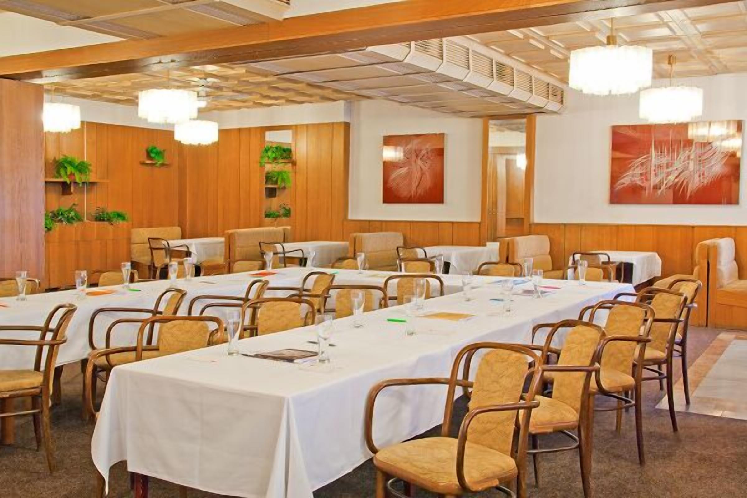 A conference room with long tables, chairs, and decorative wall art.