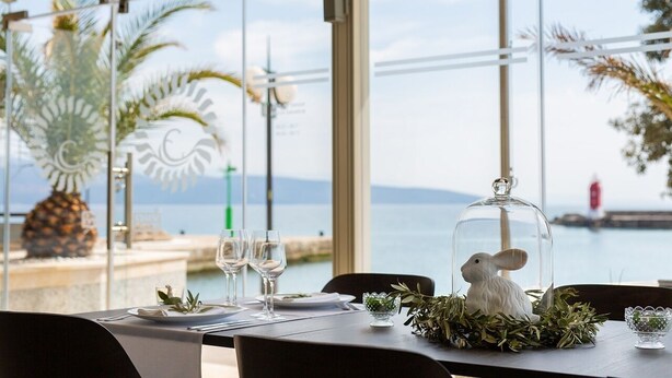 Mesa lista para comer con vista al mar y a las montañas.