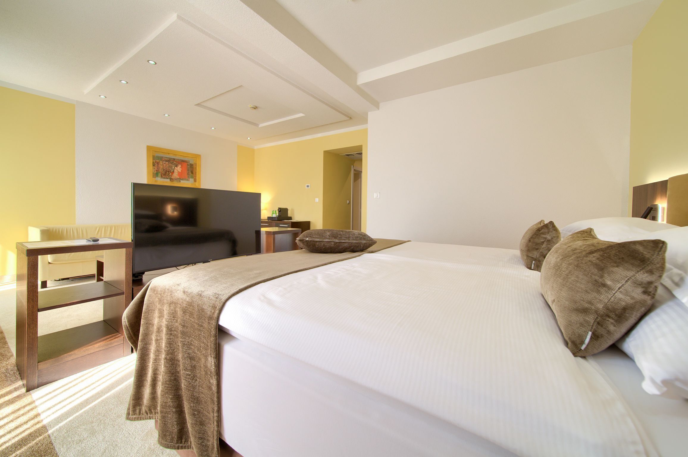 Une chambre d’hôtel avec un lit, une télévision, un bureau et une chaise.