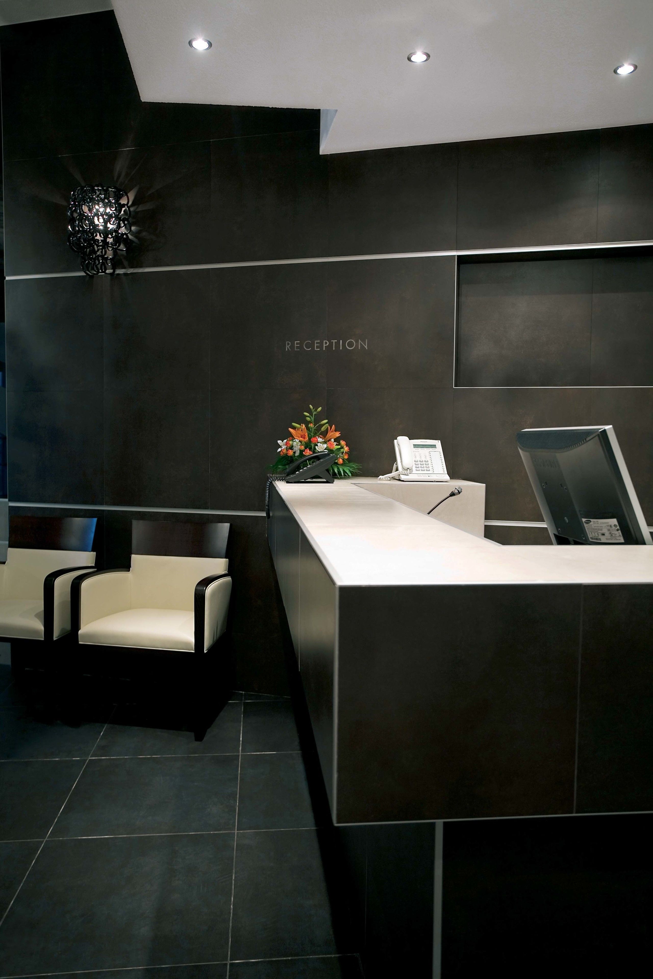 A reception area with a reception desk, a telephone, a chair, and a wall-mounted sign that reads "RECEPTION".