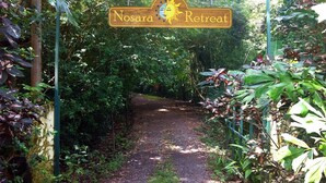 A sign for Nosara Retreat with a path leading through lush greenery. - Nosara B&B Retreat (Nosara)