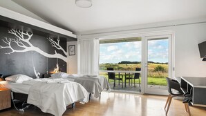 A bedroom with two beds, a desk, and a view of the outdoors. - Musholm Ferie-Sport-Konference (Korsor)