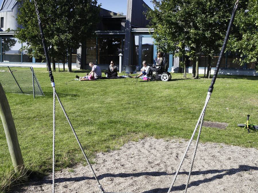Ein Spielplatz mit Schaukeln und einer Reckschaukel.